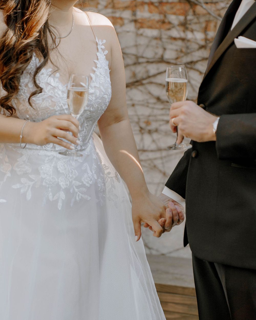 Close-up shots of a bride in a lace wedding gown with flowing tulle skirt during an intimate moment.
