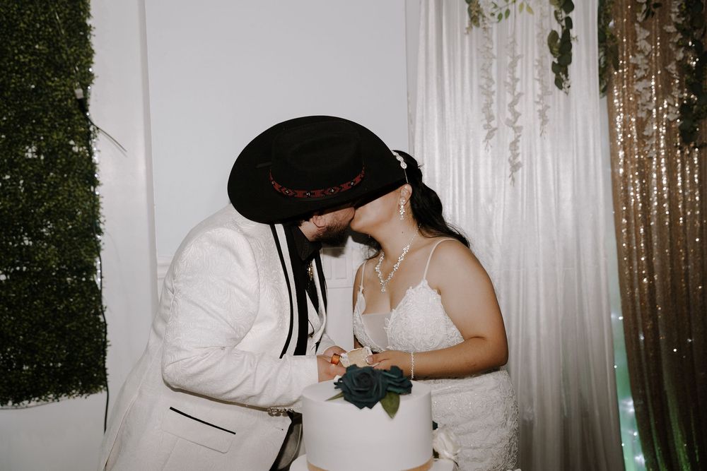 A couple in formal wedding attire share an intimate moment during their wedding reception.