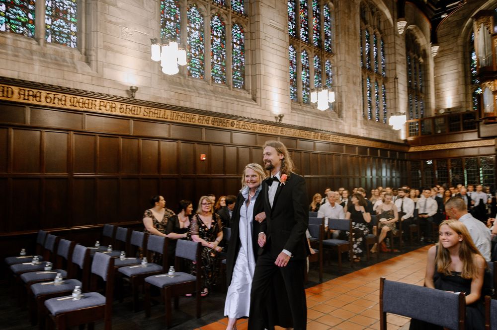 Wedding venue features wood-paneled dining hall with stained glass windows and elegant chandeliers.
