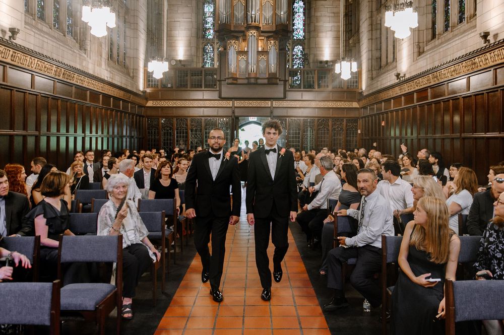 Guests seated in rows inside a historic university dining hall with grand architectural details.