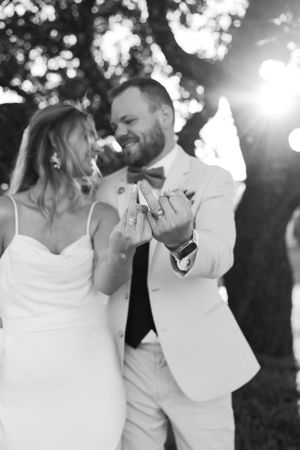 A tender black and white moment of a couple sharing a dance at their wedding, with bokeh lights glowing in the background.