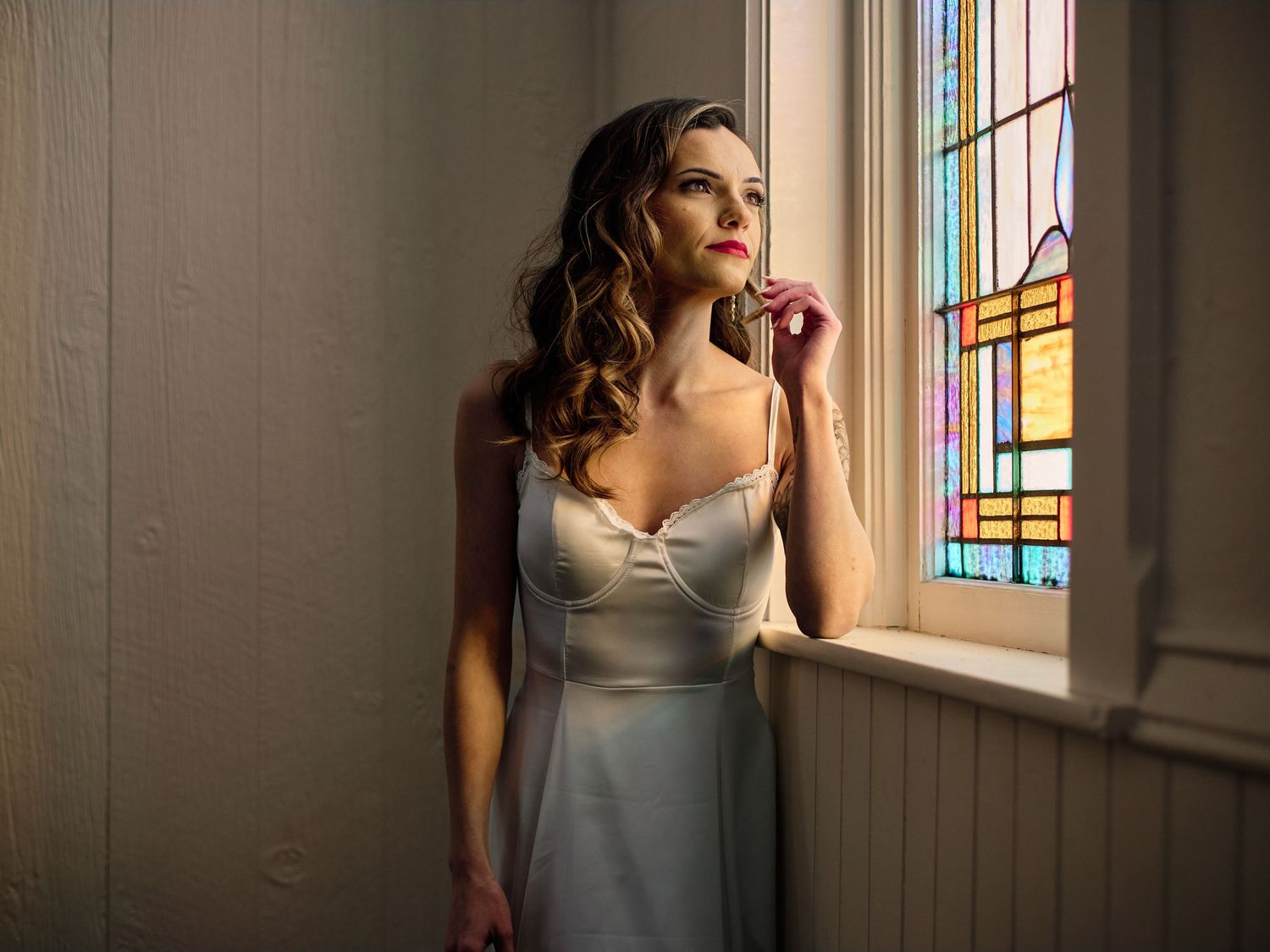 Black and white intimate wedding portrait with soft window lighting.