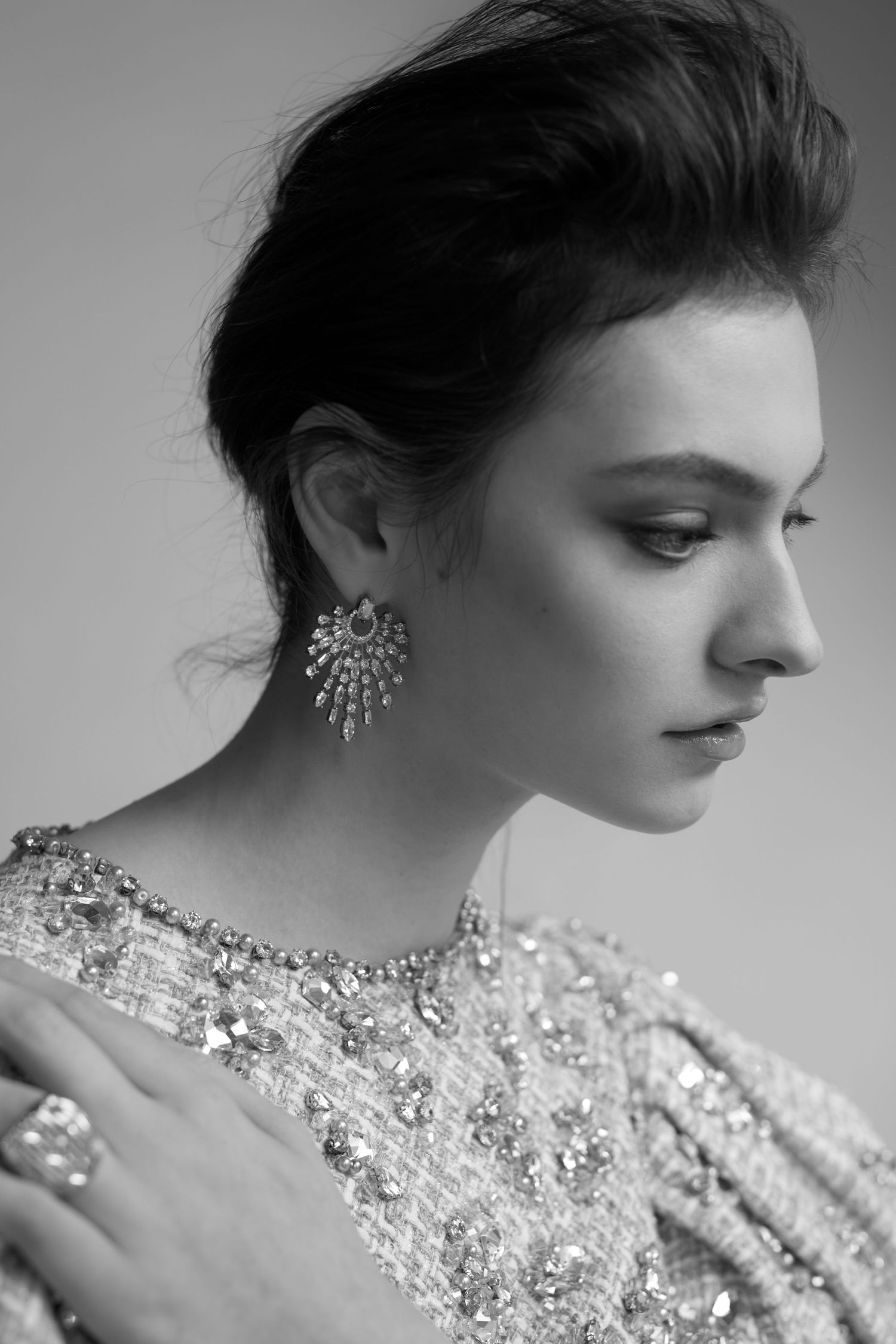 Black and white editorial style campaign portrait showcasing elegant jewelry and beaded dress details.