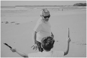 Two people playing and interacting on a sunny beach.