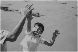 Candid black and white shot of joyful expressions during a beach photoshoot.