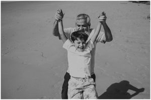 Celebratory moment captured in black and white on a sandy beach.