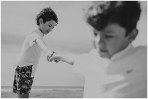 Artistic black and white composition showing two figures in profile against a beach backdrop.