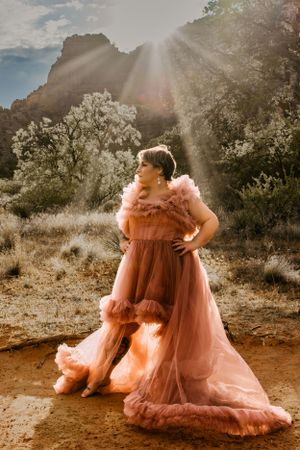 Ethereal peach tulle gown catches golden sunlight in Sedona's desert landscape.