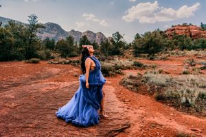Royal blue gown flows dramatically against red rock desert landscape.