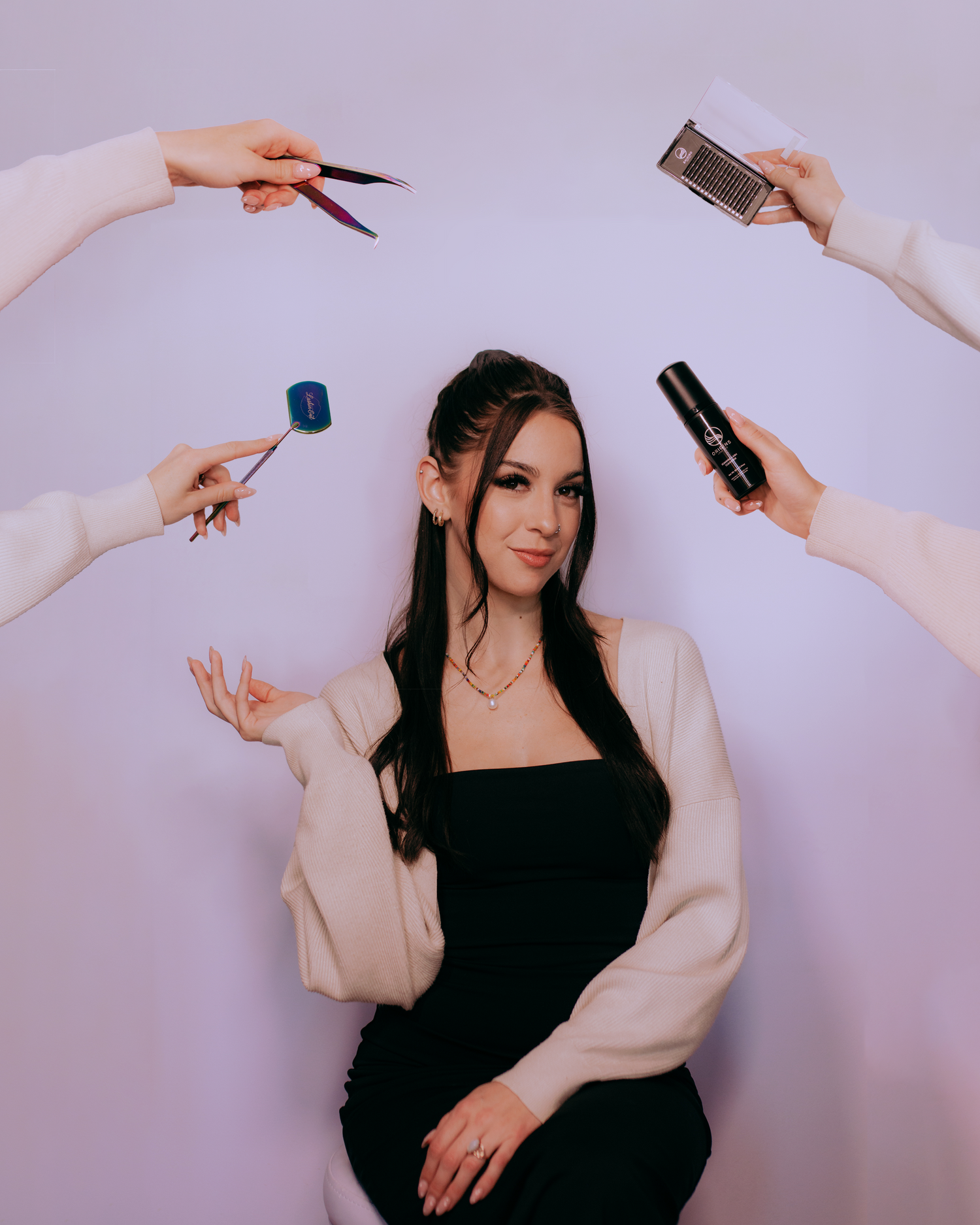 Multiple hands holding makeup brushes and beauty products against white background.