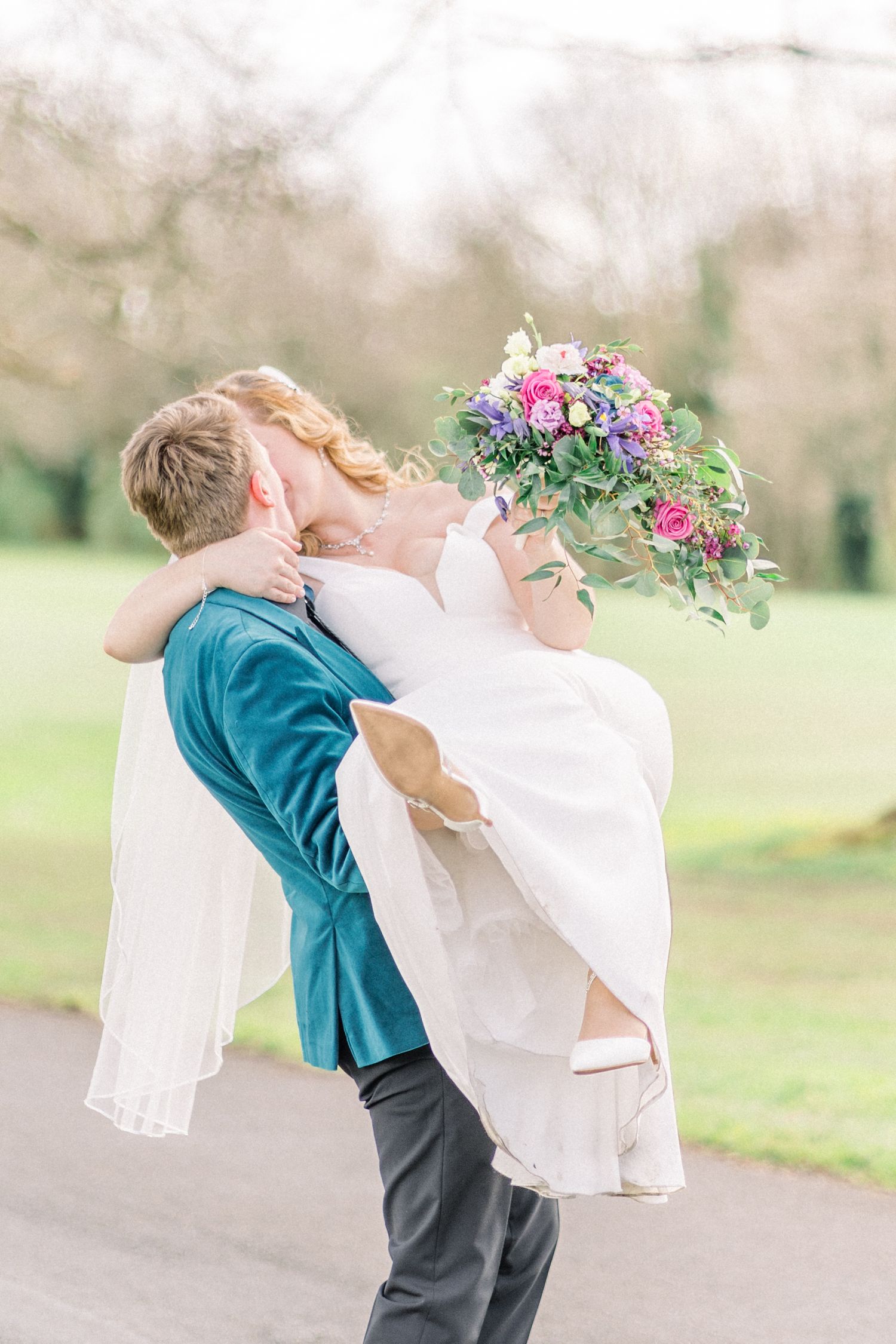 Groom lifting bride into his arms and kissing at Wollaton Hall and Deer Garden