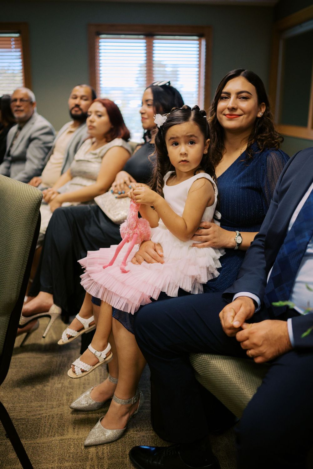 Wedding guests seated in formal attire watching the ceremony.