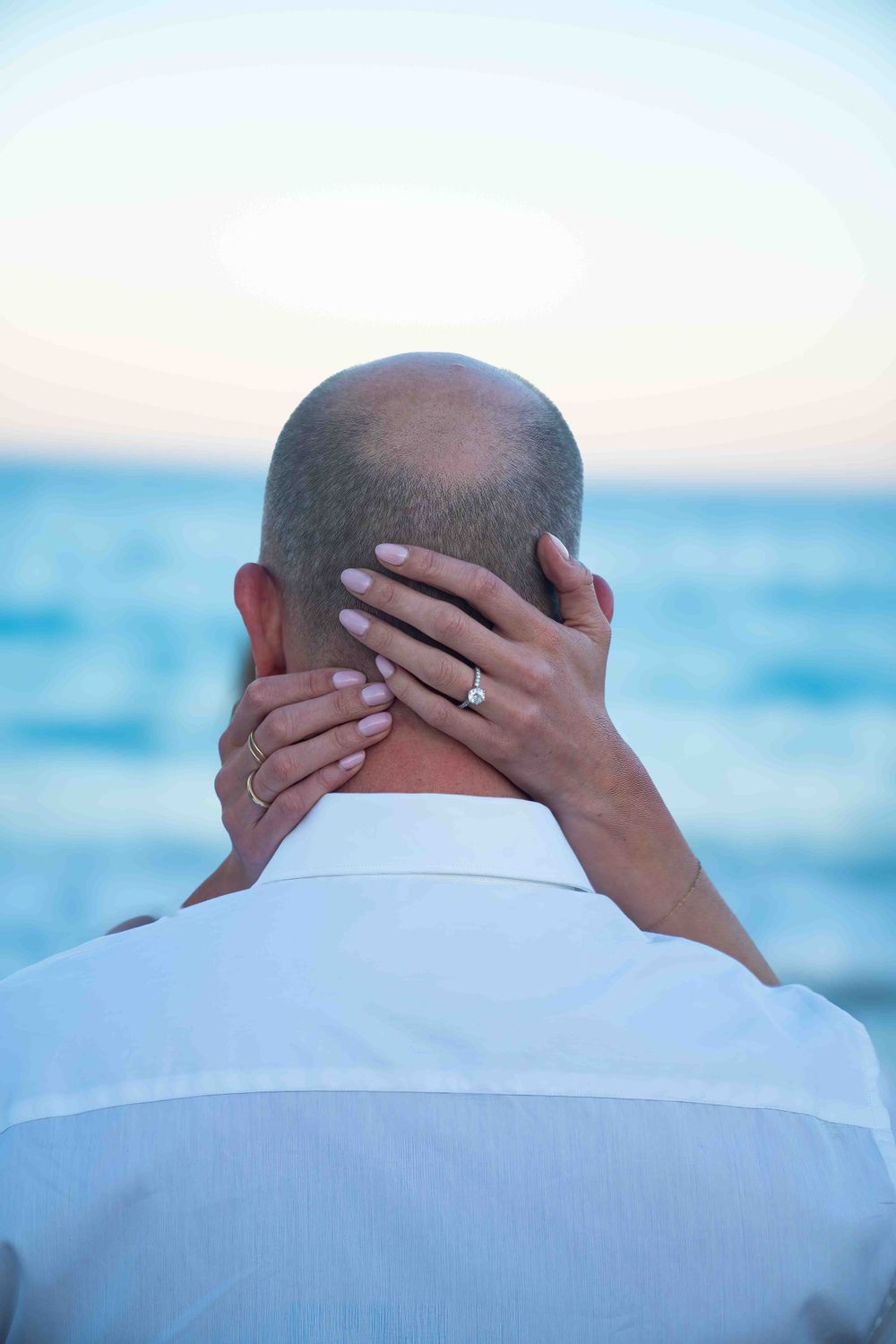 Kari resting her hands on the back of Jeff's head on the beach at Worth Ave.