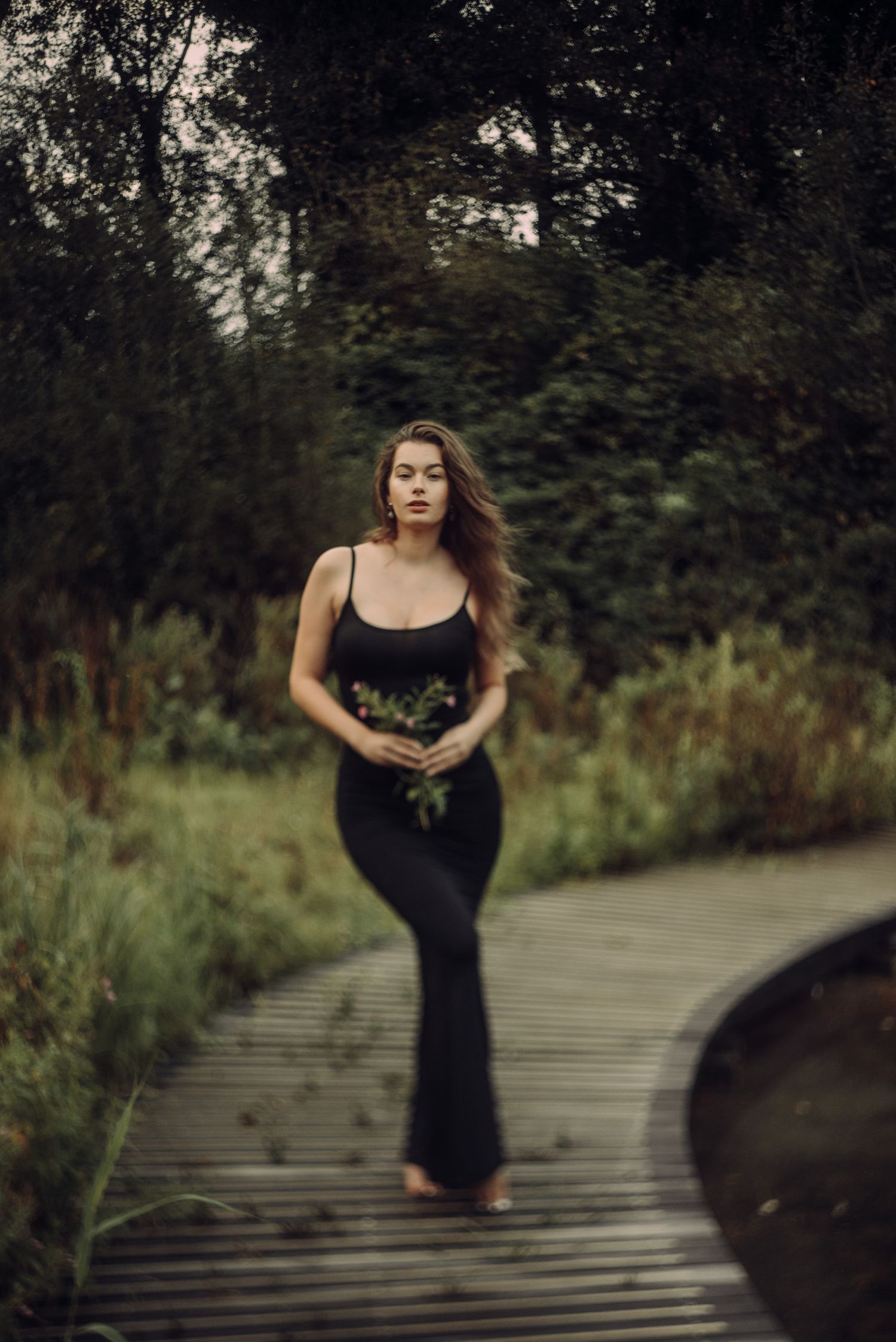 A romantic portrait of a woman in a black dress near a wooden bridge at Amsterdamse Bos.