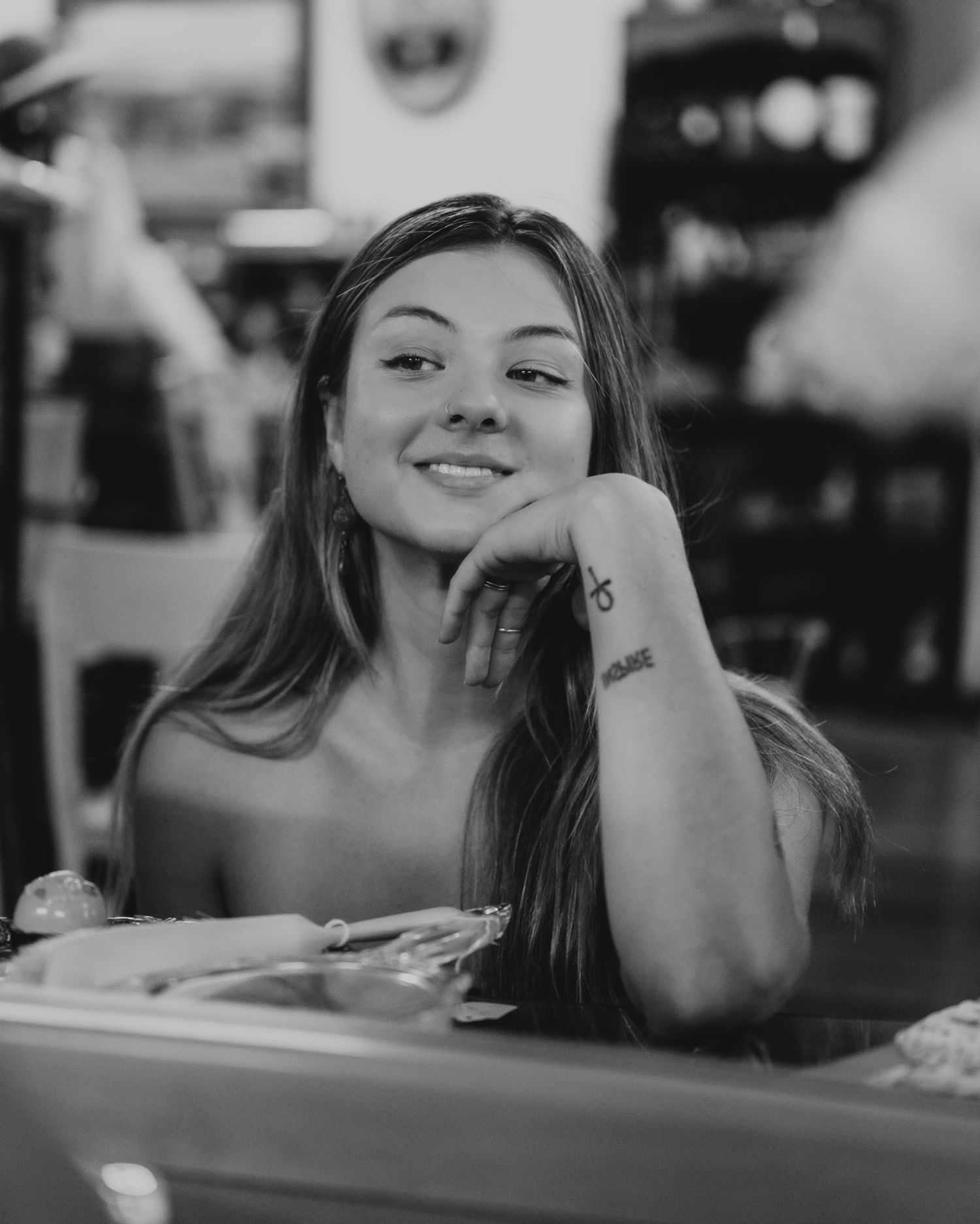 A series of connected portrait photographs showing someone resting their head on their hand at a wooden table in warm lighting.