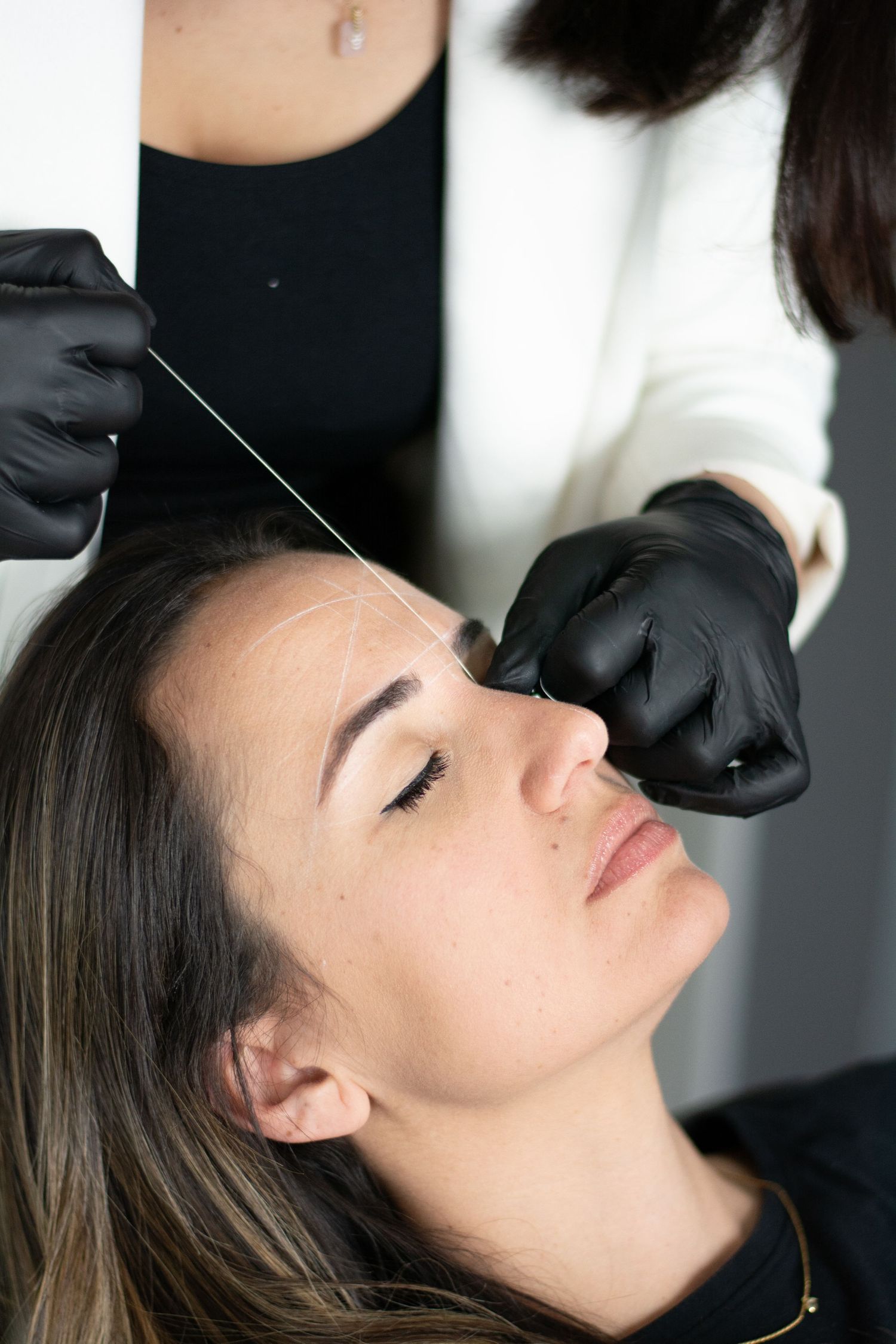 Close-up of an esthetician performing a precise facial treatment with professional tools.