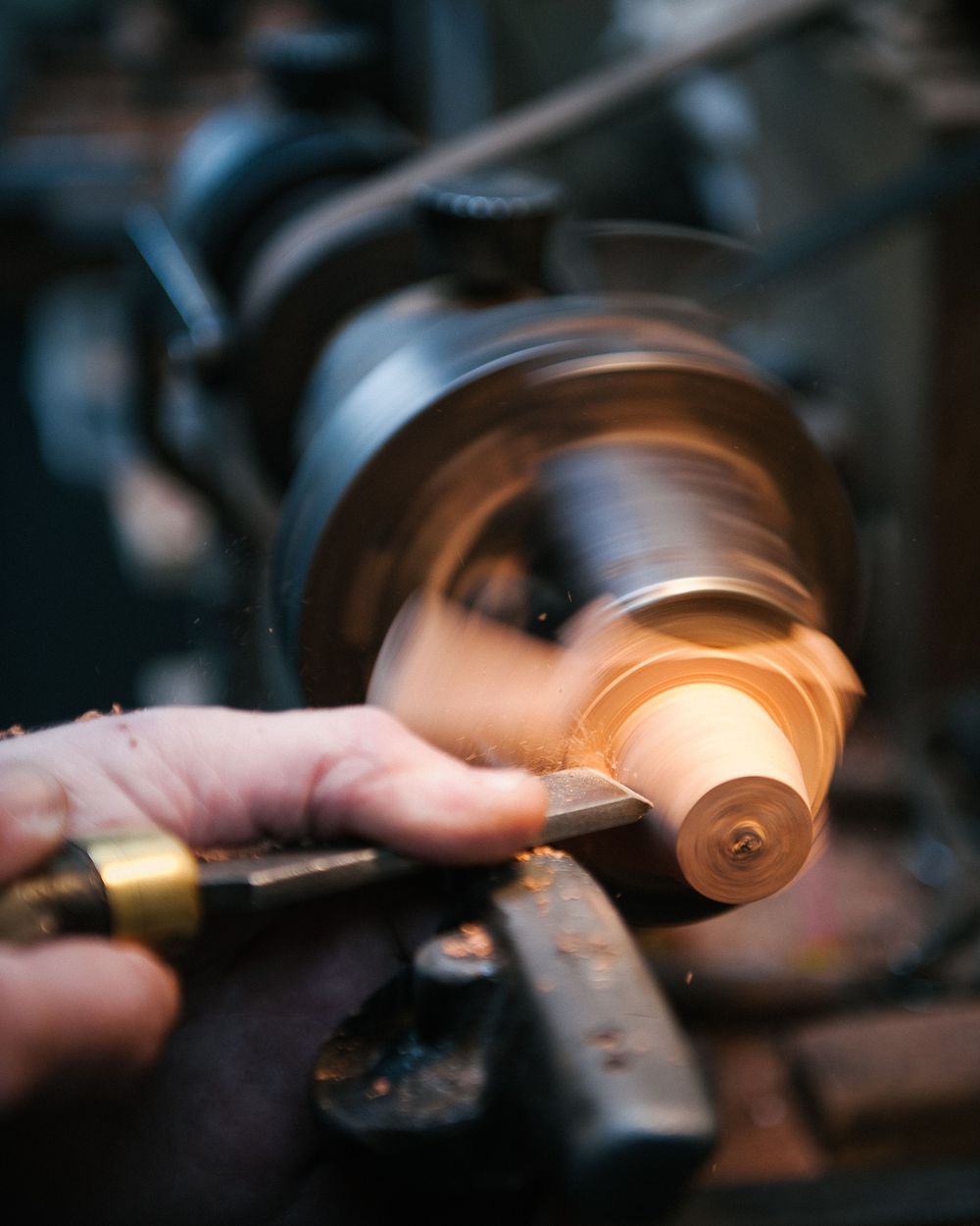 Metal lathe spinning and shaping a piece of material with motion blur effect.