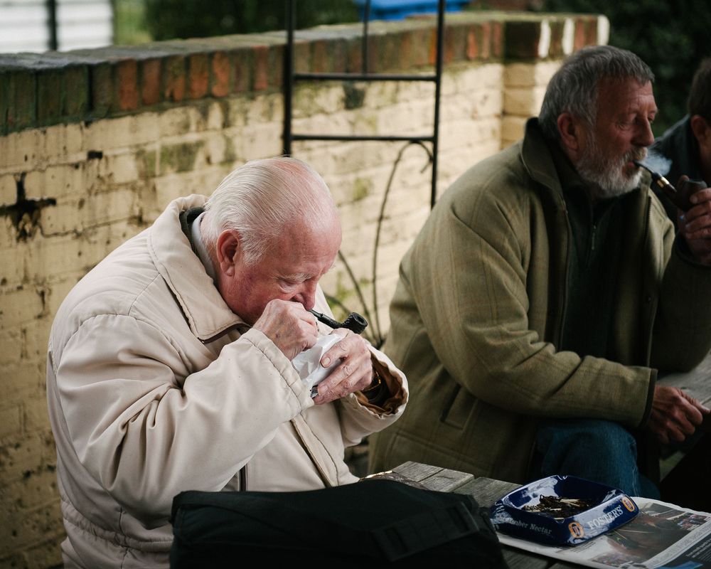 People enjoying pipes while seated together in a casual outdoor setting.