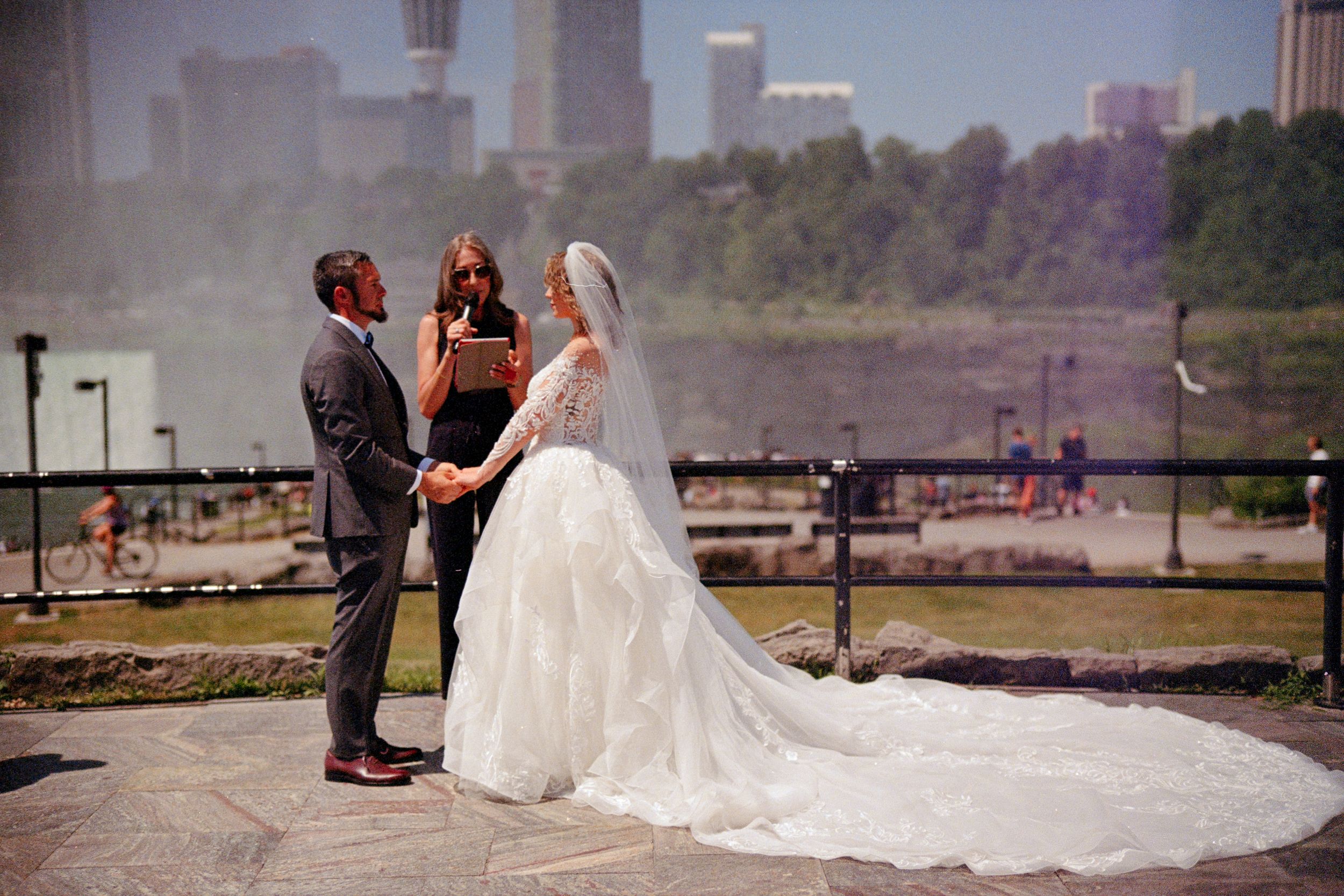 A romantic embrace between newlyweds on a beach with a flowing white wedding dress and ocean waves in the background.