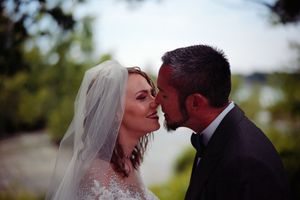 A romantic moment between newlyweds outdoors with a soft focus effect and natural lighting.