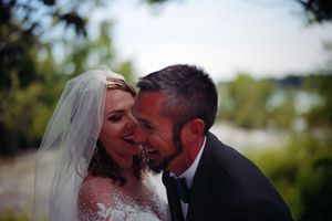 Intimate wedding moment with happy couple embracing and laughing together outdoors on their special day.
