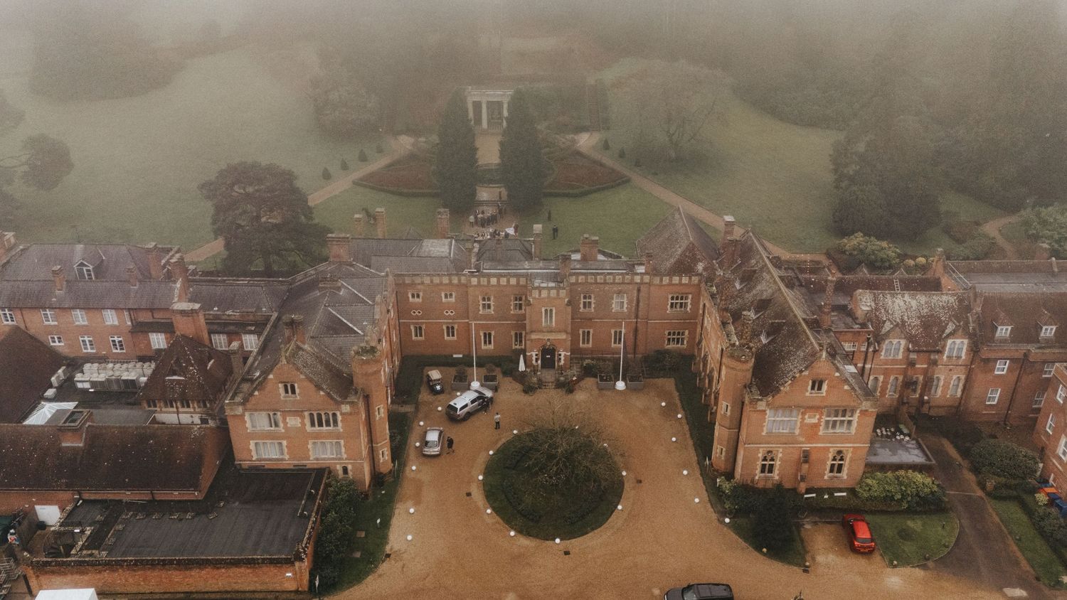 Panoramic aerial view of Georgian-style brick buildings and grounds at a historic estate property.