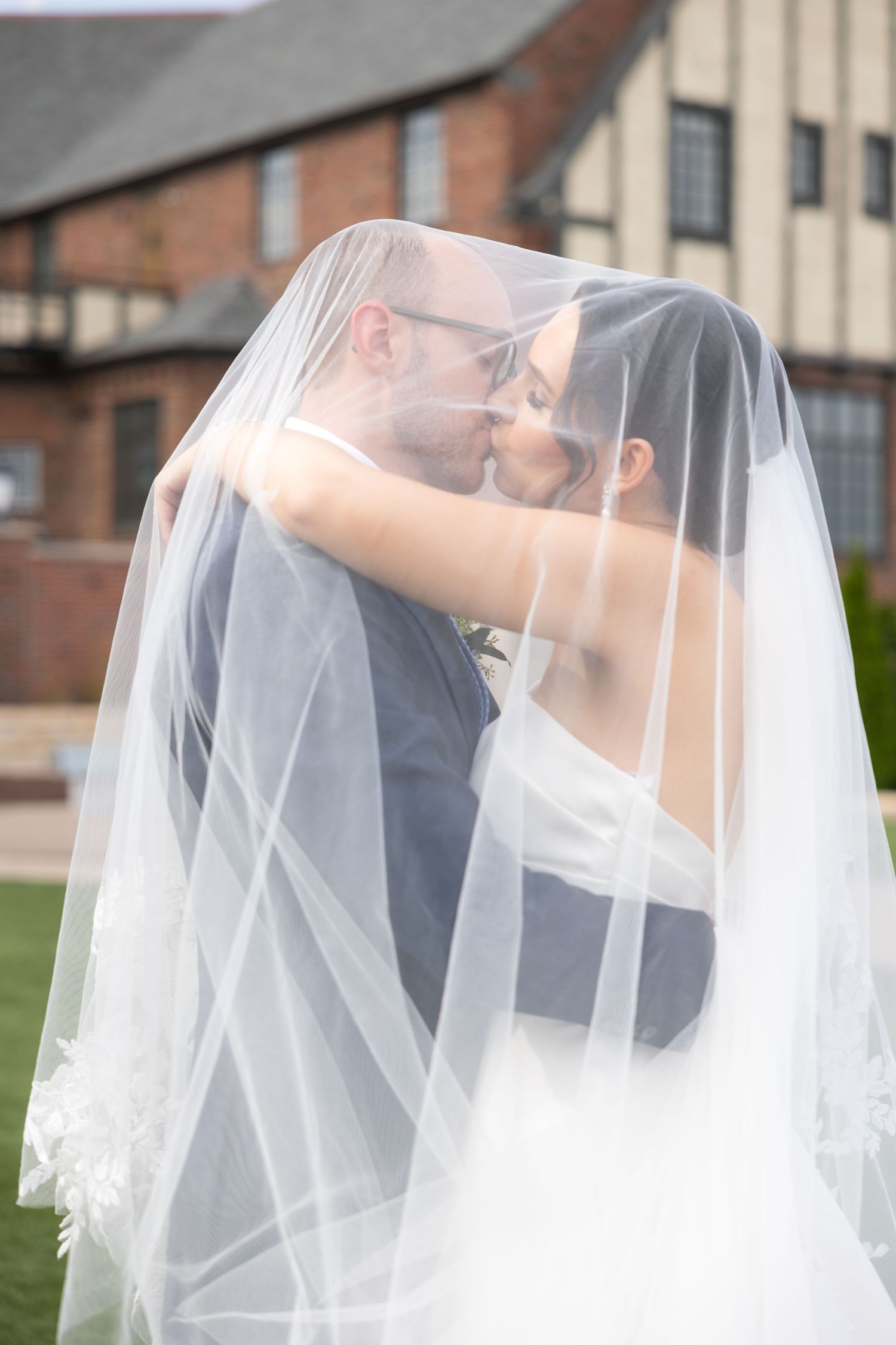 A romantic sequence of wedding photos shows a couple sharing a tender kiss under a flowing white veil. Rachel Martinez Photography Novi, MI