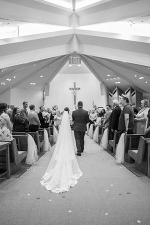 Black and white panorama of a church wedding ceremony showing guests seated in pews with center aisle.