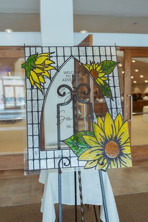 Decorative stained glass sunflower artwork displayed on easels creates an elegant wedding ceremony backdrop.