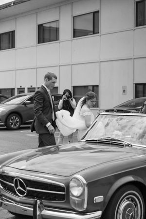 A sleek vintage Mercedes-Benz convertible being examined in an outdoor setting.