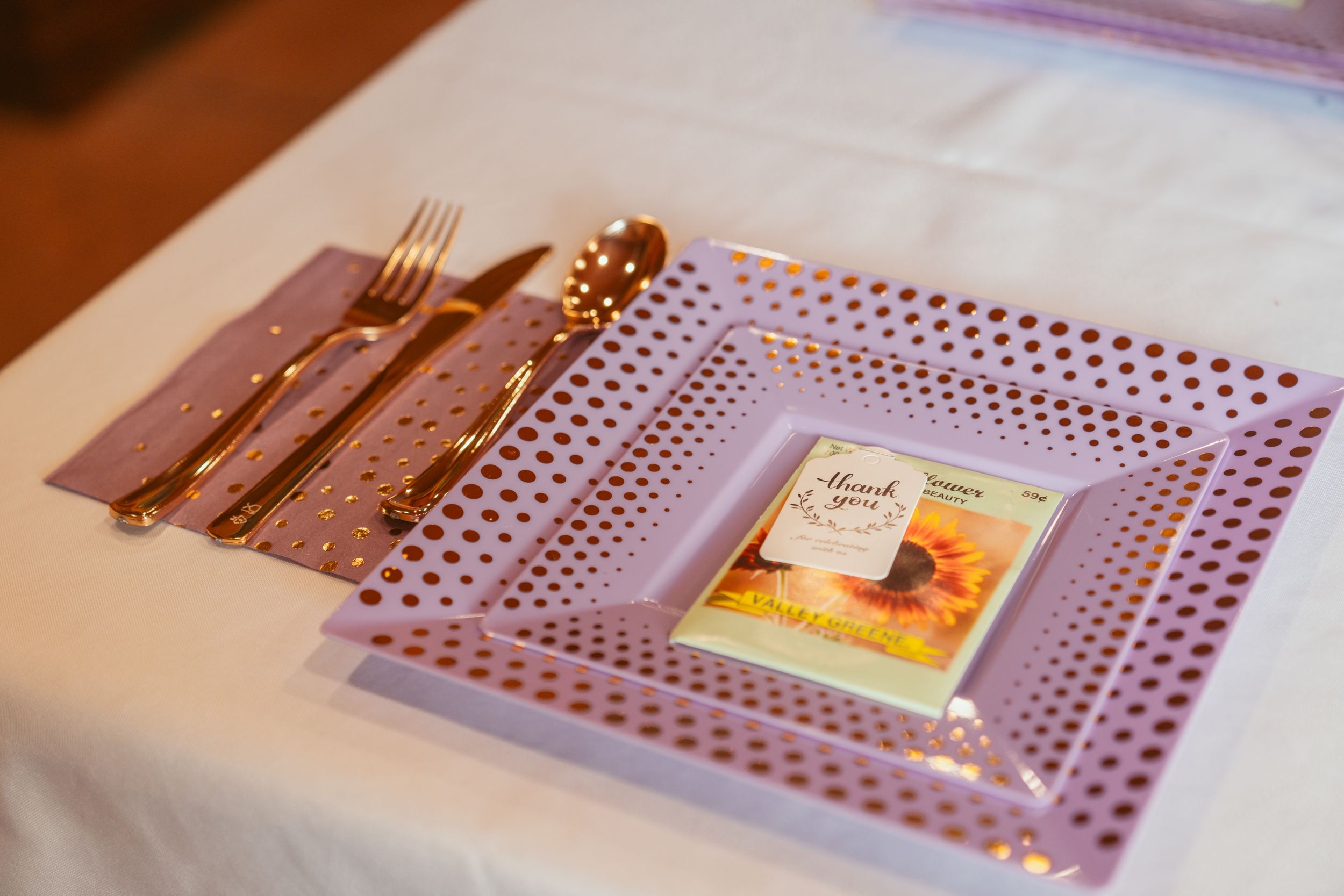 Wooden cooking utensils and a small ceramic dish arranged on a purple placemat with vintage charm.