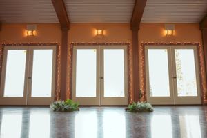Wooden beamed ceiling with decorative lighting and white accents in an elegant reception venue.