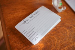 Wedding decorations and place cards arranged on a rustic wooden table with warm lighting.