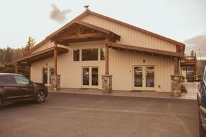 Beige exterior of a modern rustic event venue building with large windows.