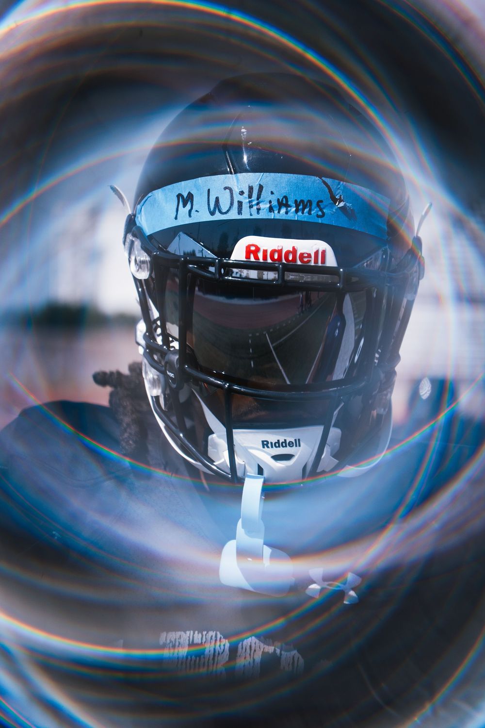 Close-up artistic shot of a Riddell football helmet with swirling vignette effect.