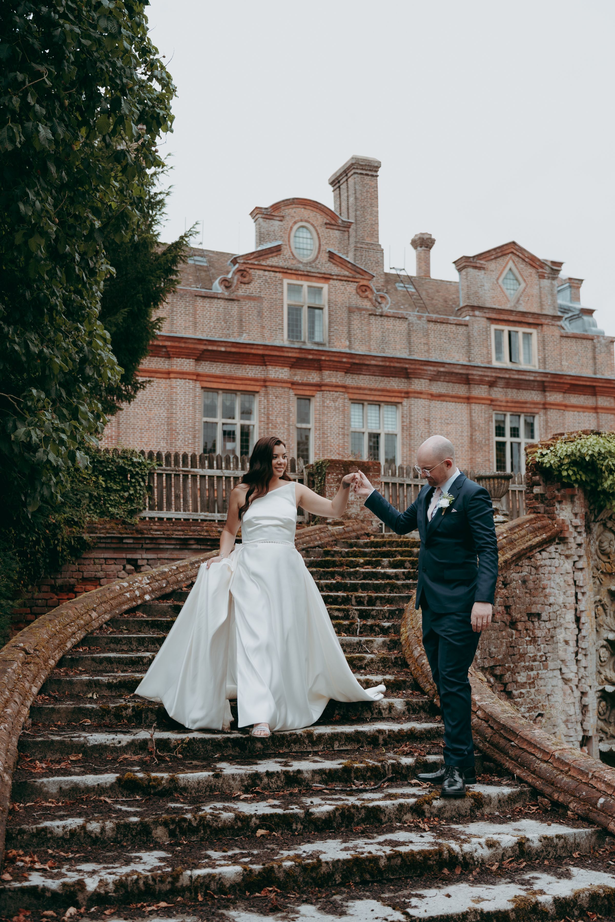 A romantic series of wedding photos showing a couple in formal attire posing on historic stone steps in front of a mansion.