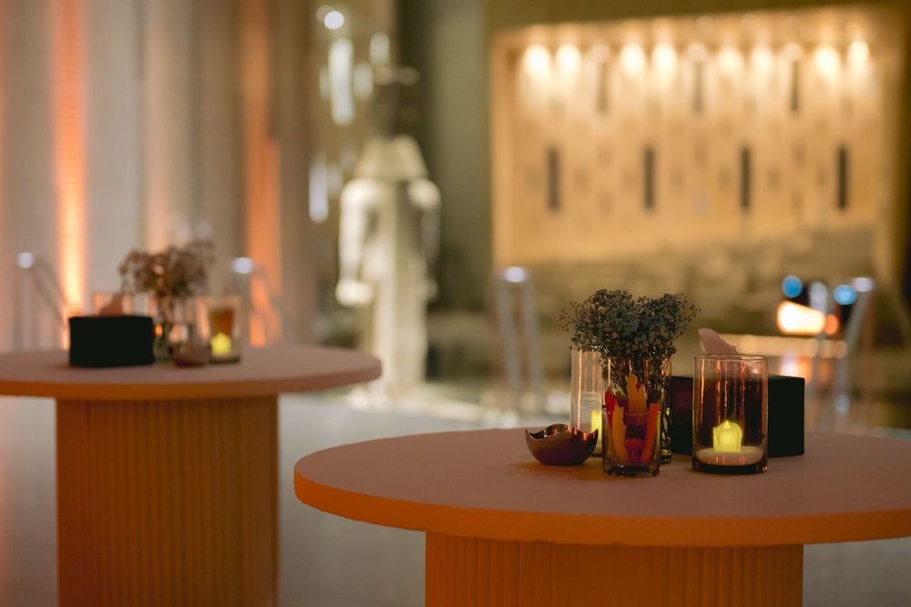 Intimate restaurant setting with candlelit round tables and warm ambient lighting.