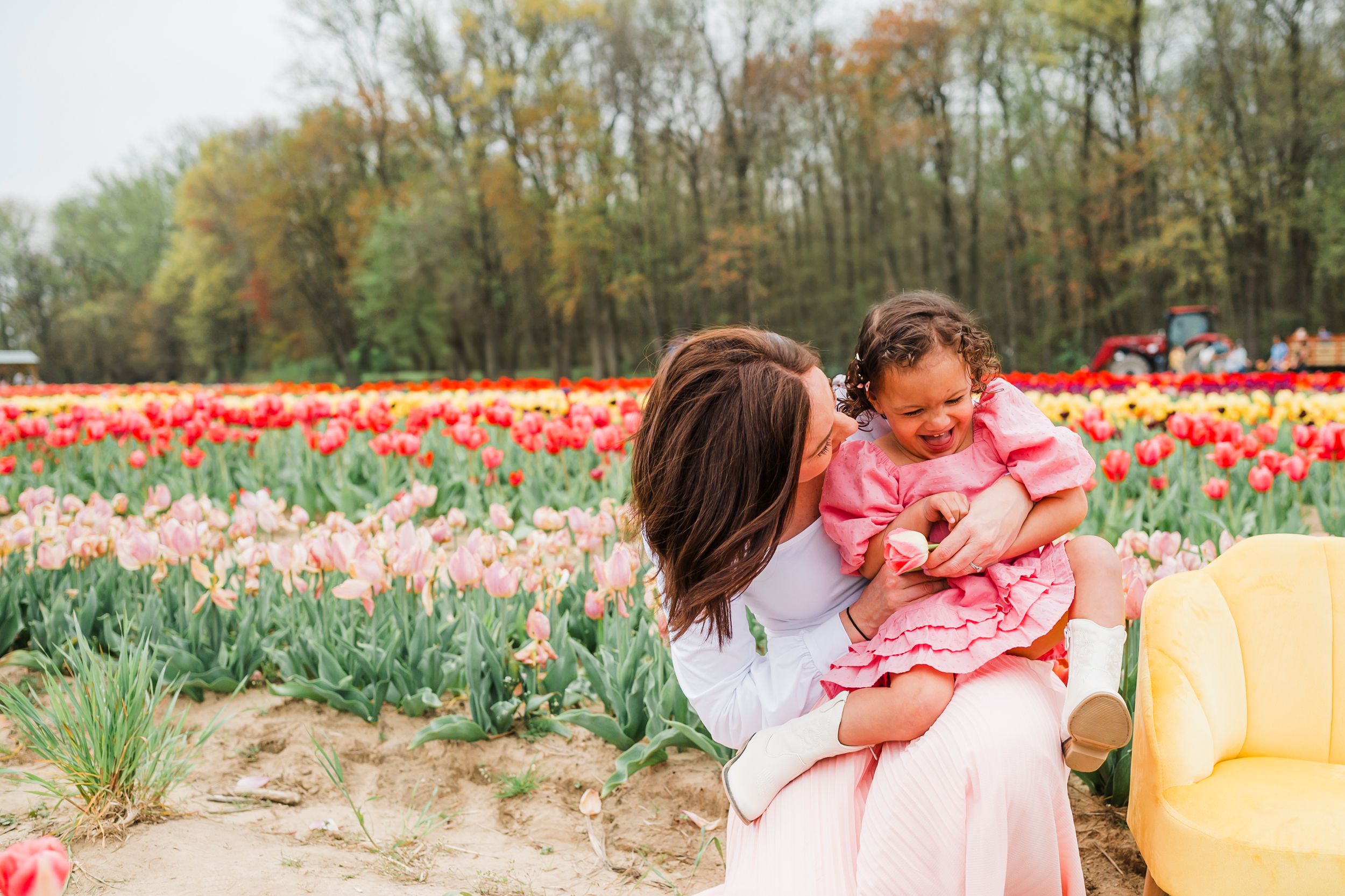 Family enjoys spring afternoon together in colorful tulip garden with blooming red and white flowers.