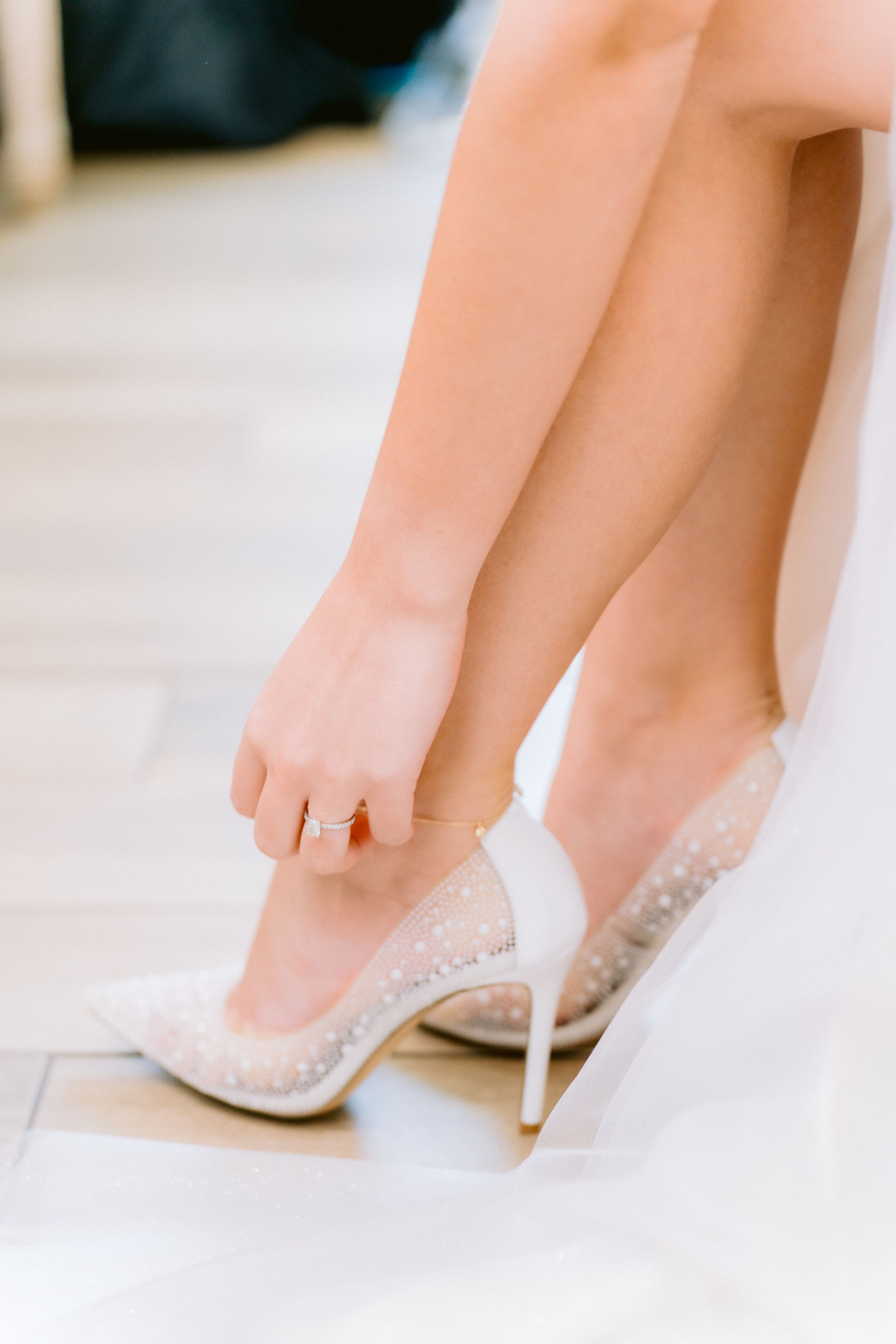 Elegant white lace bridal shoes with delicate details photographed in a stylish wedding day fashion sequence.