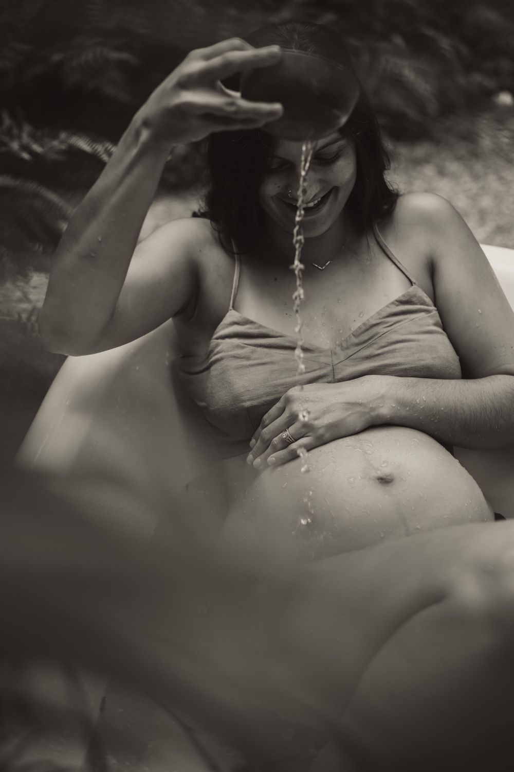 backyard bathtub maternity session where mama drips water onto her pregnant belly