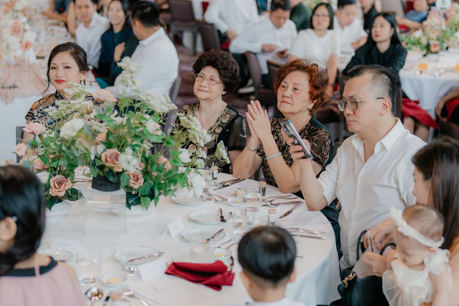 Wedding reception guests enjoying the celebration at decorated tables.