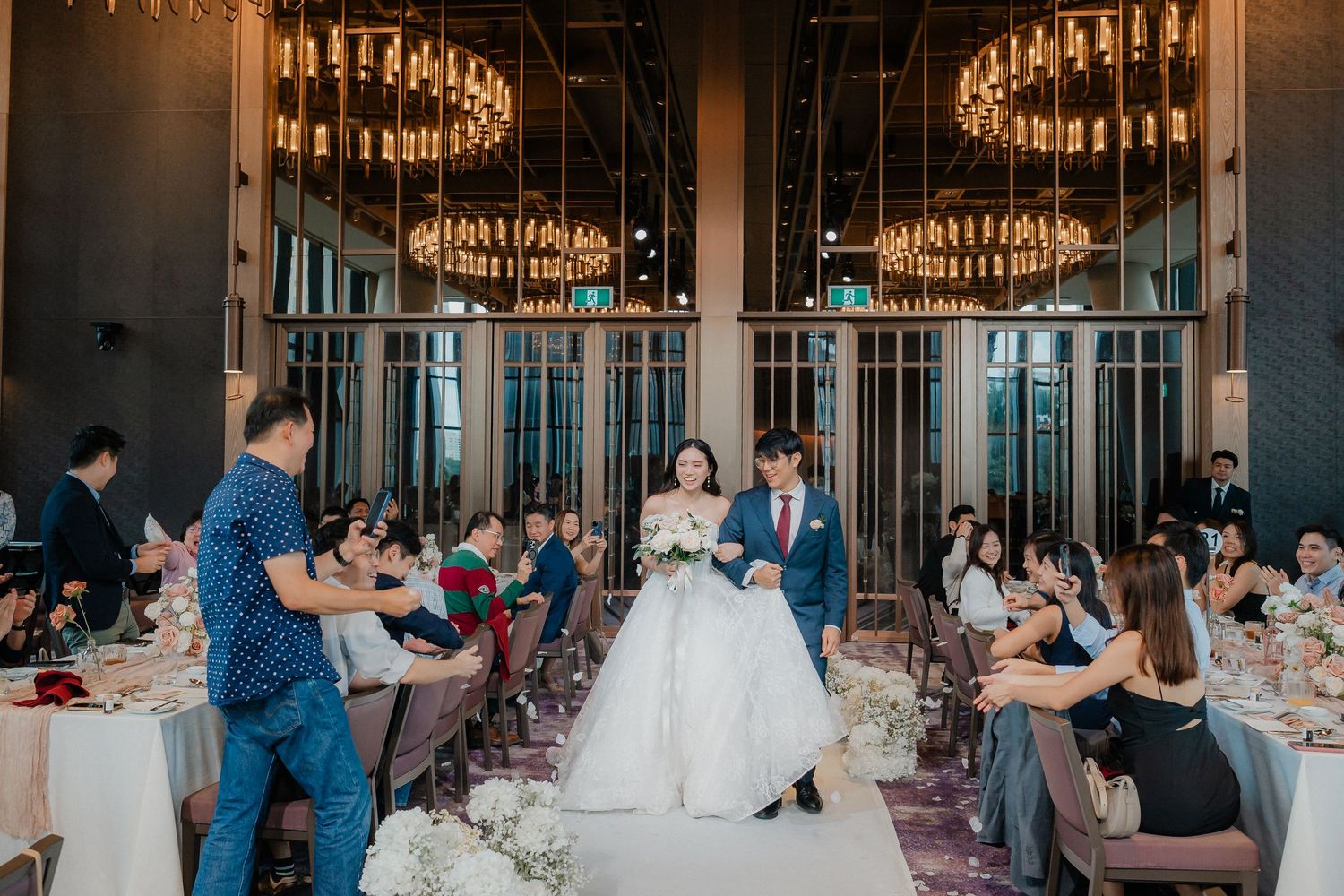 Dancing and celebration during wedding reception under magnificent chandeliers.