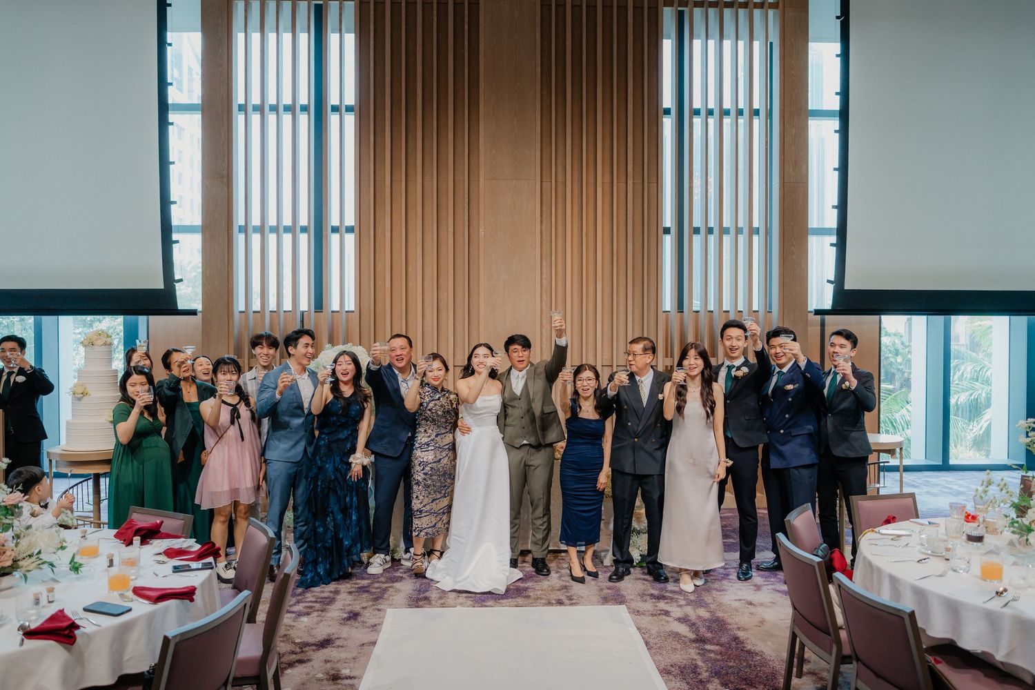 Wedding reception setup in sleek modern space with large windows and elegant table arrangements.