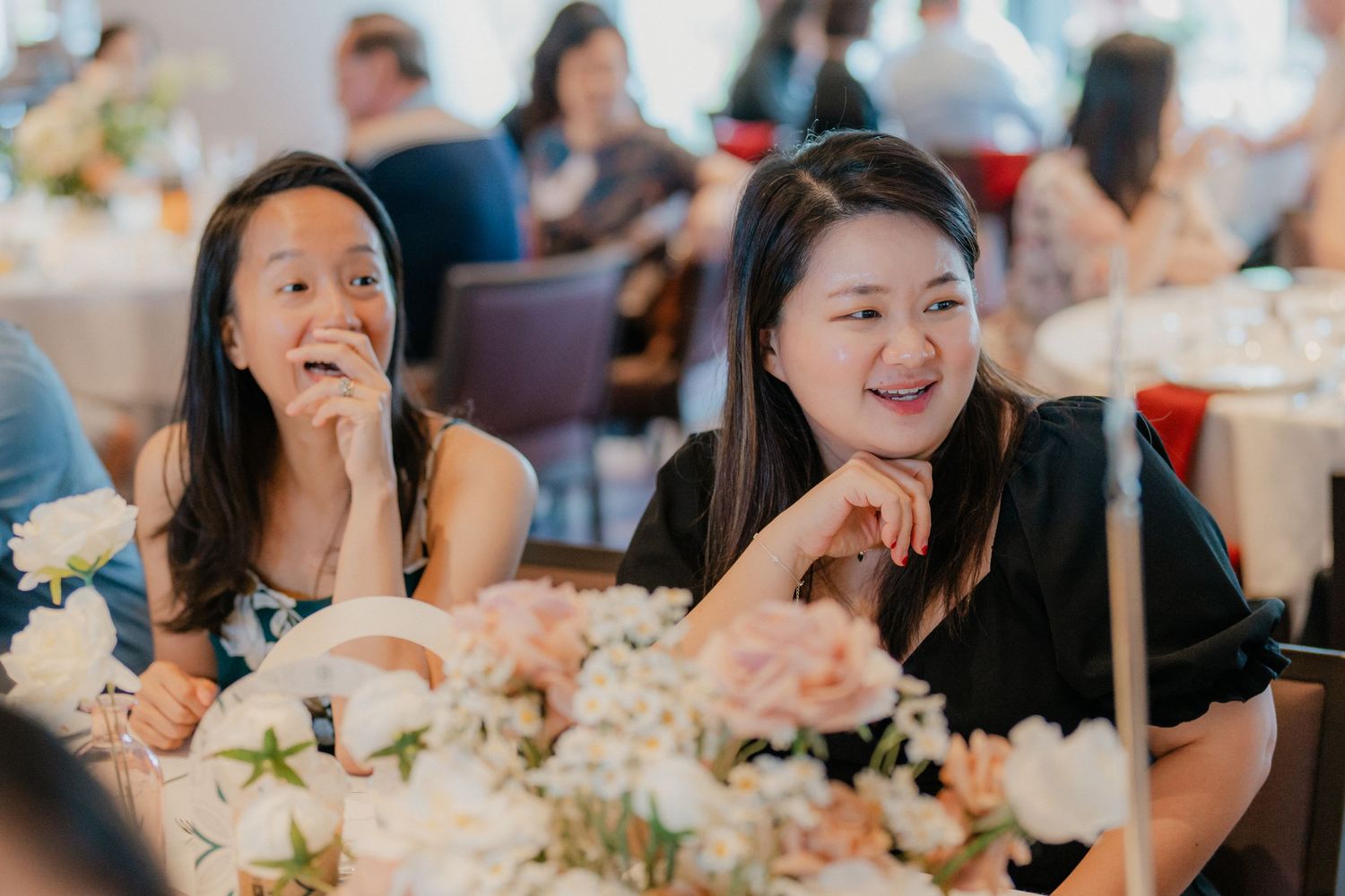 Wedding guests enjoying conversation and laughter at an elegantly decorated reception table.