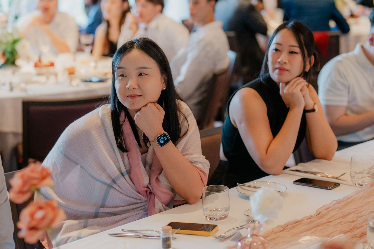 Wedding guests sitting at reception tables during celebration event.