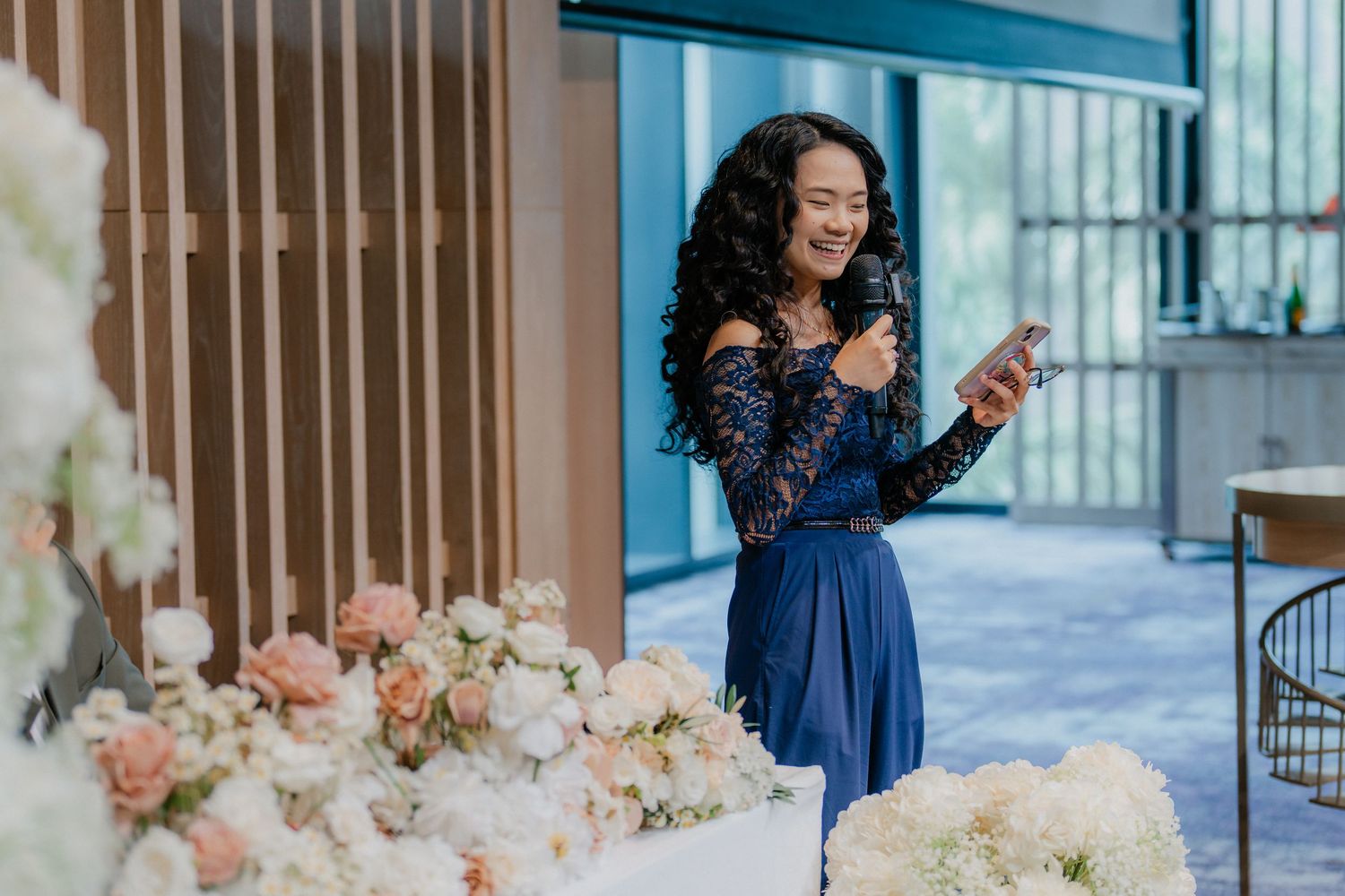 Elegant floral arrangements with blush pink and white blooms decorate wedding venue tables.