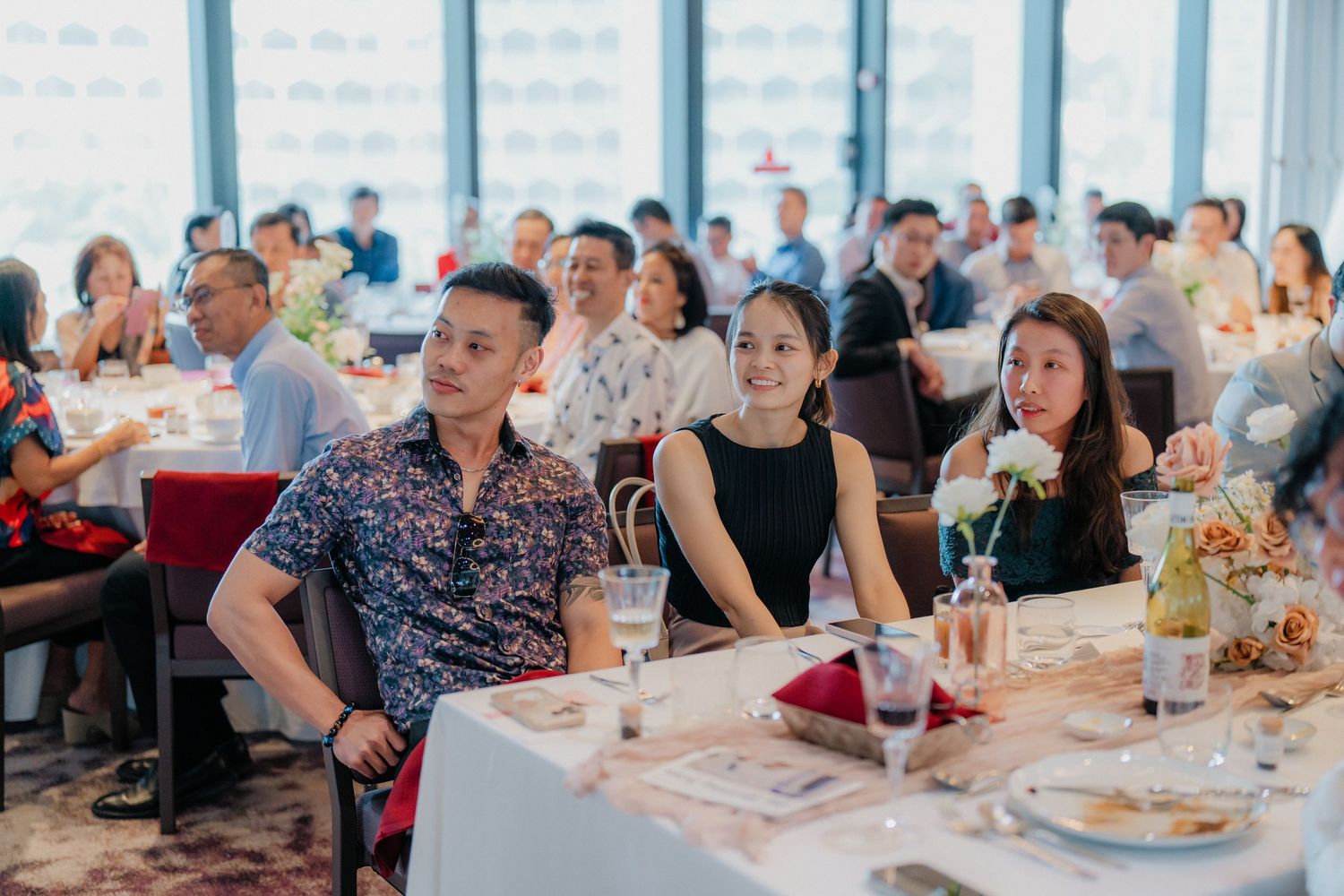 Wedding reception guests seated at decorated tables during an elegant indoor celebration event.