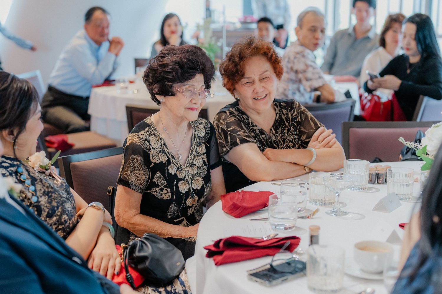 Wedding reception guests seated at decorated tables enjoying a celebratory meal together.