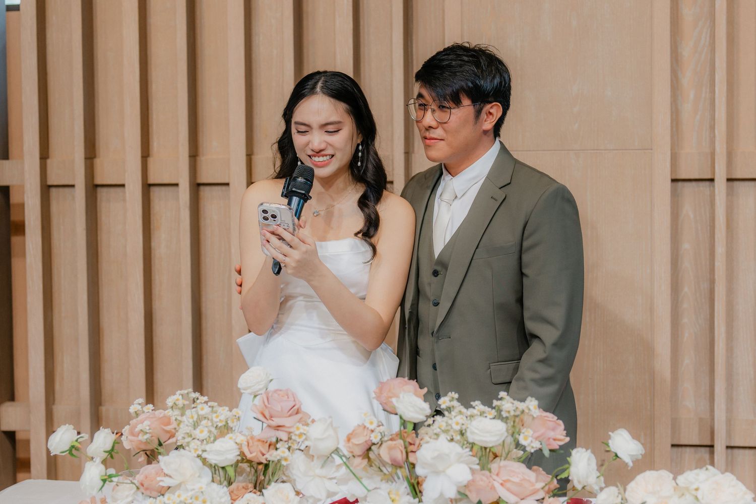 Couple sharing a sweet moment at their wedding reception decorated with pink and white flowers.