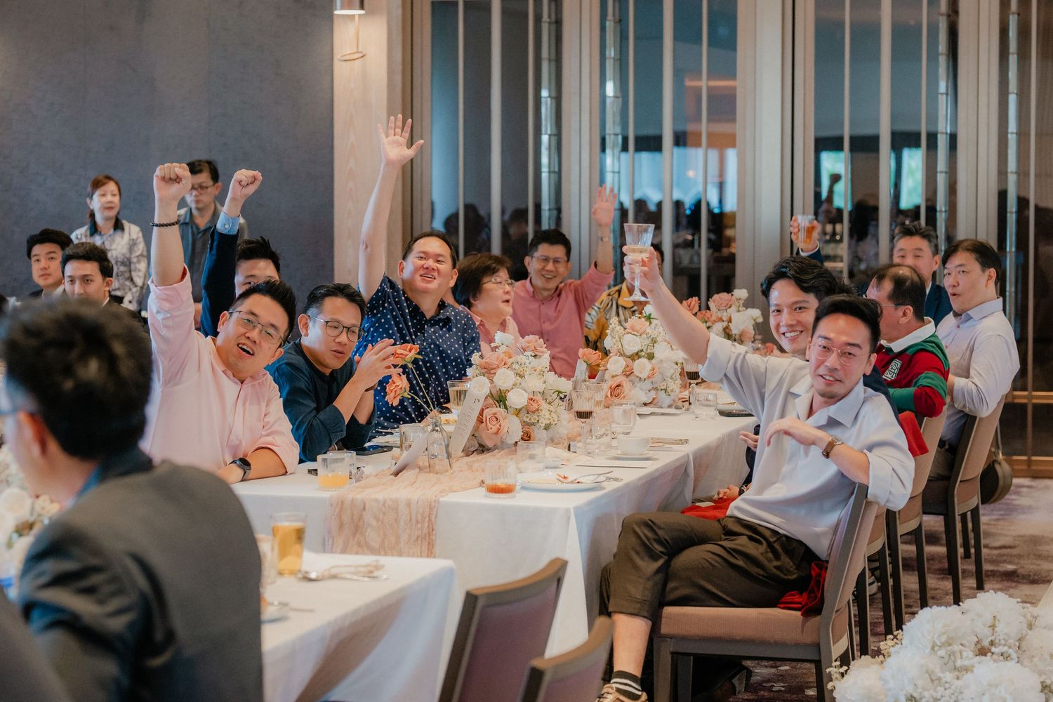 Panoramic view of wedding reception guests seated at tables in a spacious modern venue.
